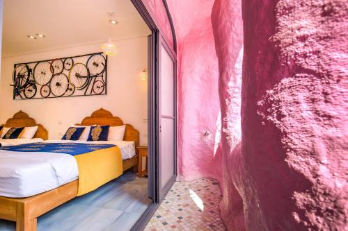 a room with a bed and a pink wall at 小琉球白沙逗琉民宿 浮潛生 態導覽 包棟推薦 in Xiaoliuqiu