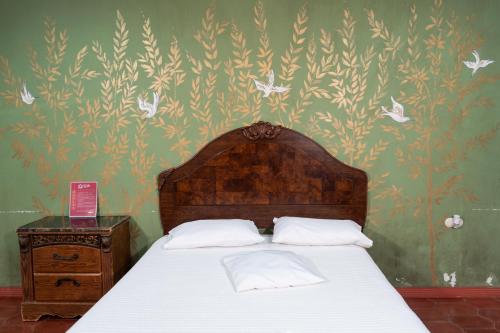 a bedroom with a bed and a wall with flowers at Hotel Posada del Rey in Santa Cruz de Yojoa