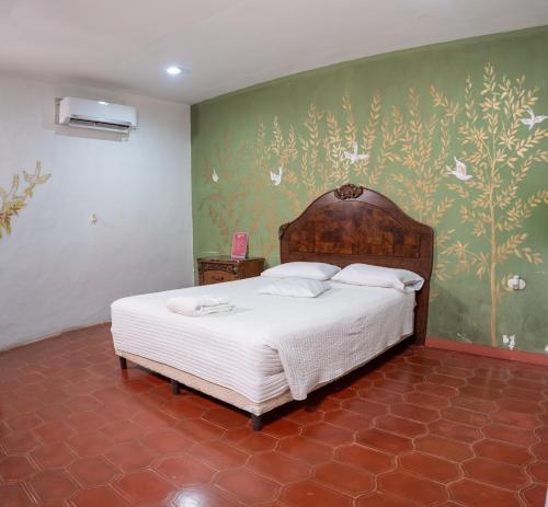 a bedroom with a bed and a green wall at Hotel Posada del Rey in Santa Cruz de Yojoa