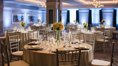 a banquet hall with tables and chairs with white table cloth at Kimpton Cardinal Hotel by IHG in Winston-Salem