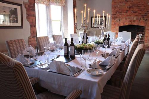 una mesa larga con copas de vino y botellas de vino en The Brownlow Arms Inn, en Grantham