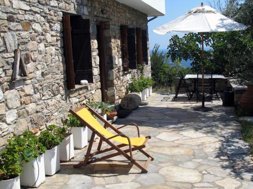 een gele stoel en een paraplu naast een gebouw bij Traditional Stonehouse in Potistika