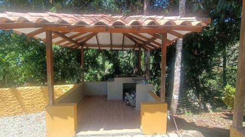 a wooden pergola with a table and chairs under it at Rancho Moralito, un lugar magico in San Carlos