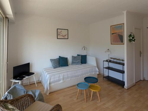 - une chambre avec un lit, deux chaises et une télévision dans l'établissement Studio charmant et lumineux avec balcon à Arcachon - Proche plage et commerces - FR-1-420-97, à Arcachon