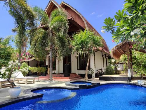 吉利阿尔Gili MoonLight RetReat的房子前面有棕榈树的游泳池