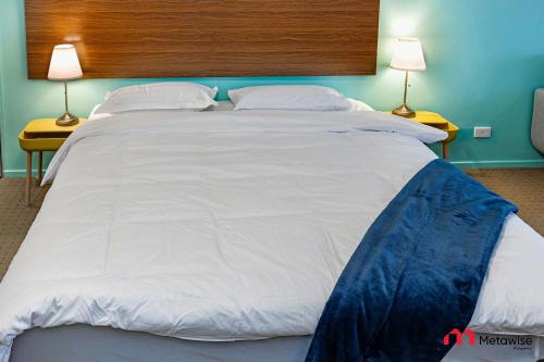 シドニーにあるMetaWiseBnB Studio Dixon Next to ICC & Darling Harbour 23のランプ2つが備わる客室の大きな白いベッド1台