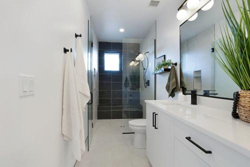 a white bathroom with a shower and a toilet at Desert Oasis Close to Zion Pool and Hot Tub in Kanab