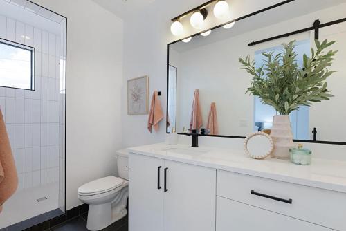 a white bathroom with a toilet and a mirror at Desert Oasis Close to Zion Pool and Hot Tub in Kanab
