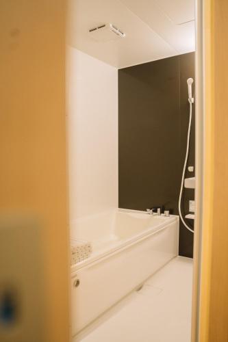 妙高市にあるMatsuya hotelのバスタブと鏡のあるバスルーム