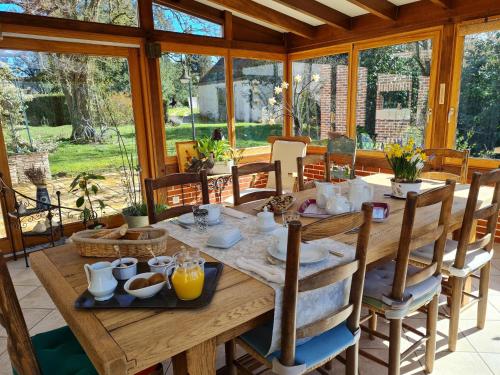 une salle à manger avec une table et des chaises en bois dans l'établissement Grande maison calme avec jardin et rivière - FR-1-590-263, à Saint-Martin-dʼAbbat