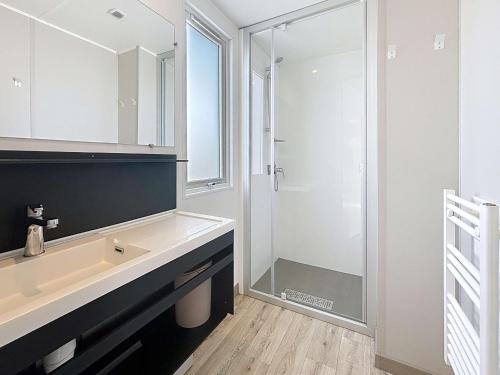 une salle de bain avec un lavabo et une douche dans l'établissement Mobil-home Grand Confort à Jullouville - Plage, Piscine Chauffée, Fitness et Parking - FR-1-361A-66, à Jullouville