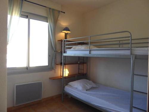 deux lits superposés dans une chambre avec fenêtre dans l'établissement Appartement 2 pièces, vue mer, Accès plage, Parking - FR-1-776-132, à Argelès-sur-Mer