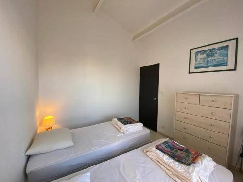- une petite chambre avec 2 lits et une commode dans l'établissement Appartement T2 avec terrasse et parking à 50m de la plage - FR-1-413-257, à Capbreton