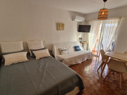 un salon avec un lit et un canapé dans l'établissement Studio climatisé près de la plage et commerces, parking, animaux acceptés, Sainte-Maxime - FR-1-780-92, à Sainte-Maxime