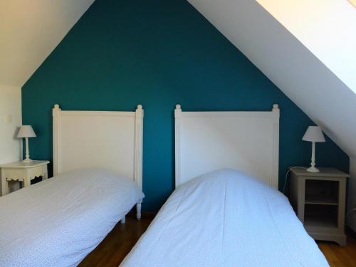 2 letti in una camera da letto con parete verde di Maison individuelle à Contres avec piscine partagée - FR-1-491-465 a Le Controis En Sologne