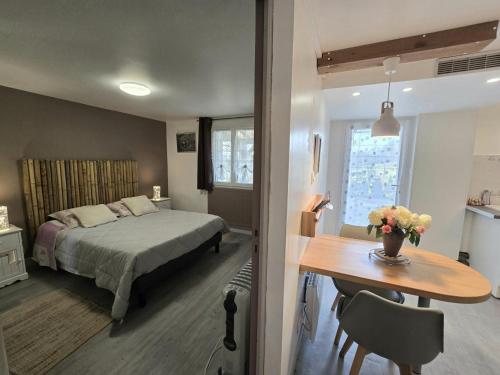 a bedroom with a bed and a desk and a table with flowers at Appartement cosy avec terrasse et piscine dans le Périgord Noir - FR-1-616-473 in Saint-Chamassy