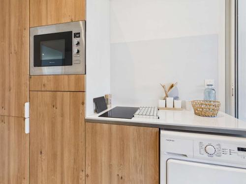 une cuisine avec un évier et un micro-ondes dans l'établissement Maison 8 pers Front de Mer - Grau d'Agde - FR-1-423-320, au Grau-dʼAgde