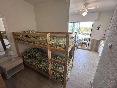une chambre avec deux lits superposés dans une pièce dans l'établissement Studio pour 4 à Port Camargue avec Climatisation et Parking - FR-1-731-135, au Grau-du-Roi