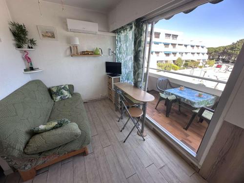 - un salon avec un canapé et une table avec un balcon dans l'établissement Studio pour 4 à Port Camargue avec Climatisation et Parking - FR-1-731-135, au Grau-du-Roi