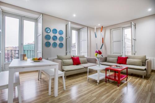 uma sala de estar com um sofá e uma mesa em Mola Suites em Madri