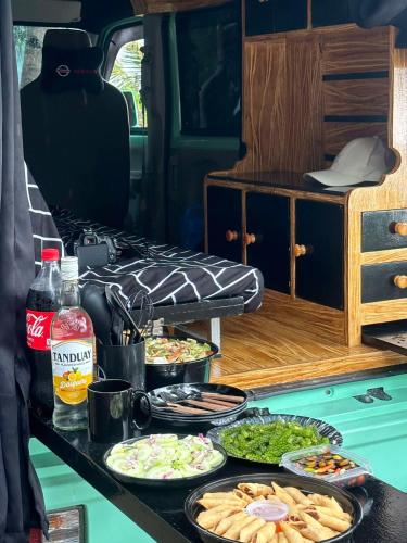 a table with many plates of food on it at Camper Van for Rent-Mini , El Nido in El Nido