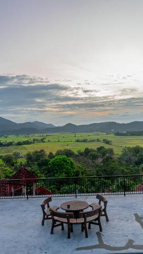 a table and benches on a patio with a view at The Bukit Resort Langkawi in Kampung Padang Masirat