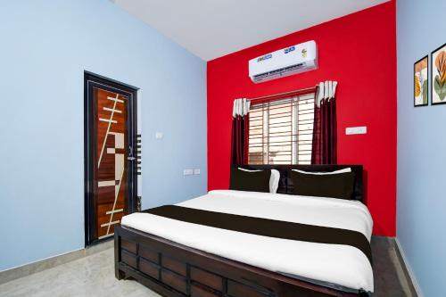 1 dormitorio rojo y azul con 1 cama grande en Hotel O Spacious Villa, en Bhubaneshwar