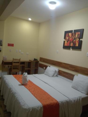 a bedroom with two beds and a painting on the wall at Casa Nativa Iquitos in Iquitos