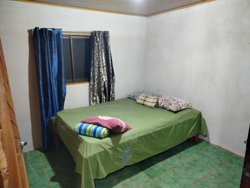 a small bed in a room with a window at Cabaña el mirador in San José