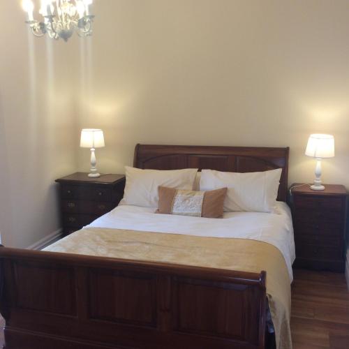 a bedroom with a large bed with two night stands at St Columbs House in Buncrana