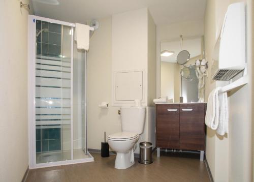 La salle de bains est pourvue de toilettes et d'une douche en verre. dans l'établissement Odalys City Orléans Saint Jean, à Orléans