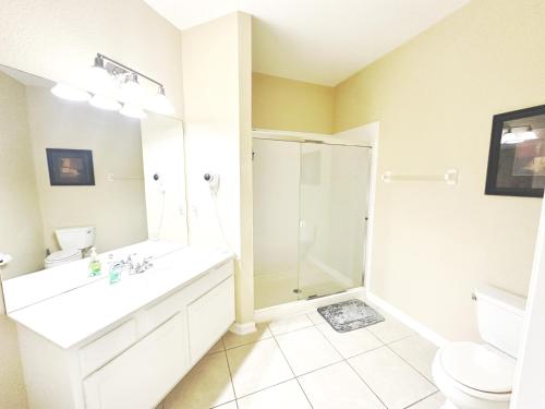 Un baño blanco con ducha y lavabo. en Master Room with Private Bath nearby Conv Center & Epic, en Orlando