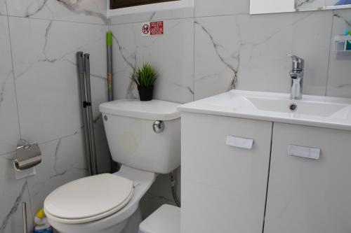 a white bathroom with a toilet and a sink at Apartment,NEAR THE BEACH Pinikoudes in Larnaka