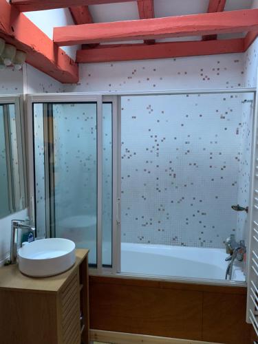 une salle de bain avec une douche en verre et une baignoire dans l'établissement Appartement Espelette, à La Celle-sous-Gouzon