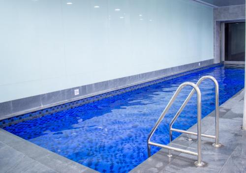 a swimming pool with blue water in a building at Koala Nest in Central Adelaide in Adelaide