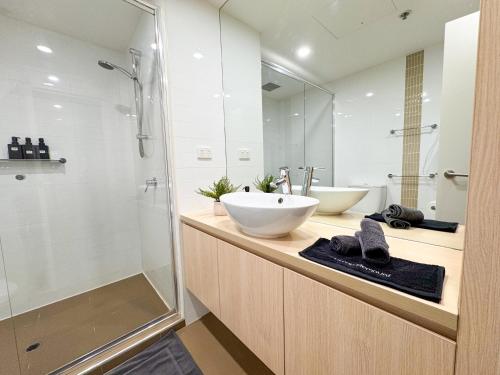 a bathroom with two sinks and a glass shower at Koala Nest in Central Adelaide in Adelaide