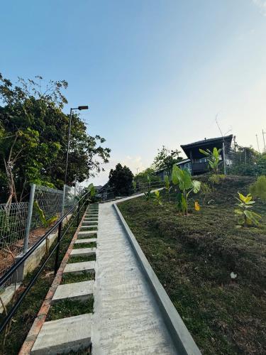 a walkway in a park next to a fence at The Bukit Resort Langkawi in Kampung Padang Masirat