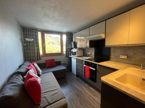 un salon avec un canapé et une cuisine dans l'établissement Studio le Palafour, ski-in ski-out, à Tignes