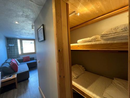 une chambre avec deux lits superposés et un canapé dans l'établissement Studio le Palafour, ski-in ski-out, à Tignes