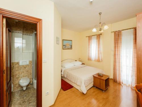 una camera da letto con un letto e un bagno di Hotel Adria a Kaštela (Castelli)