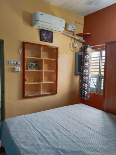 a bedroom with a bed and a mirror and a window at Sithaphal tree villa in Hospet
