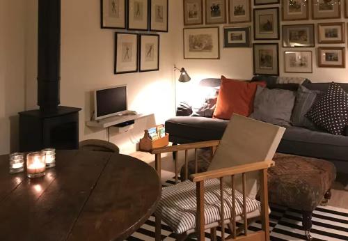 a living room with a couch and a table at Stylish small barn near coast private garden Pass the Keys in Saint James