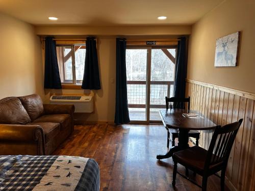 a living room with a couch and a table with a table at Methow River Lodge and Cabins in Winthrop