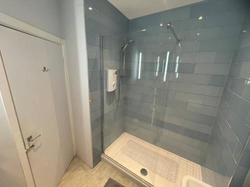 a bathroom with a shower with a glass door at Overlooking the sea - Spacious apartment in Littlehampton