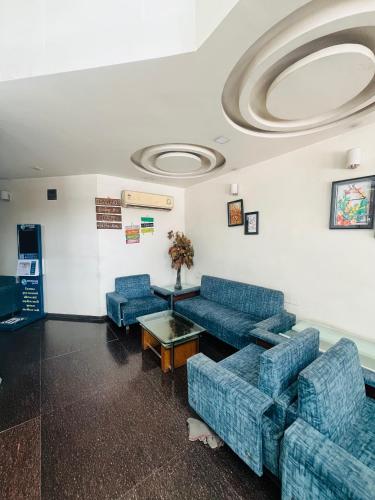 a waiting room with blue couches and a table at Mangal Darshan I just 1km from shreenathji temple 966o9o1oo6 in Nāthdwāra