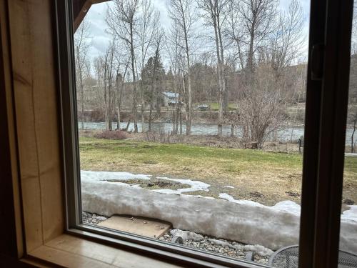 a window with a view of a field with snow at Methow River Lodge and Cabins in Winthrop
