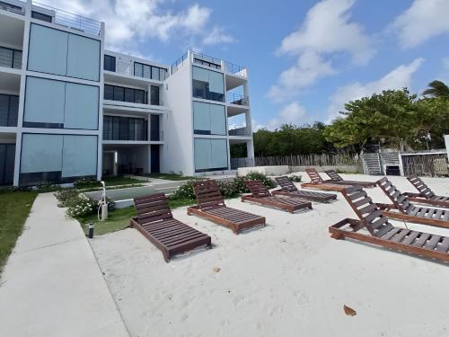 a row of lounge chairs in front of a building at Oceanfront 2Bed - 2Bath Paradise Mahahual in Mahahual