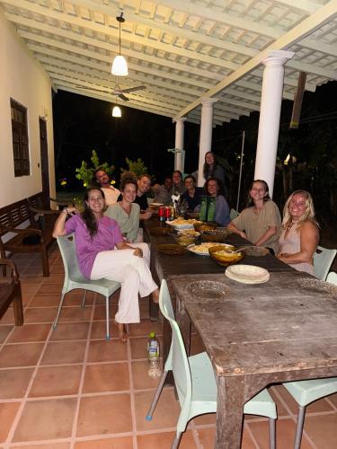 un grupo de personas sentadas en una mesa en KA Surf Hostel, en Ahangama