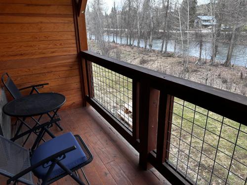 a porch with two chairs and a table and two windows at Methow River Lodge and Cabins in Winthrop