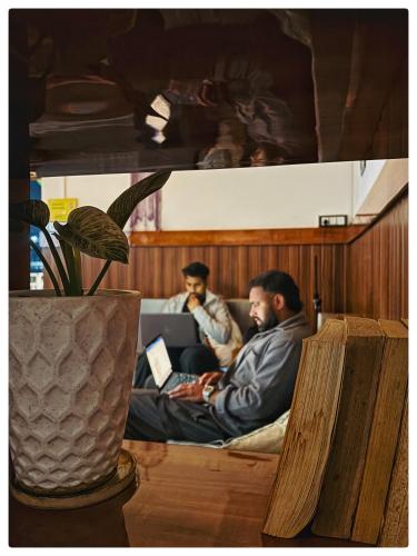 two men sitting on a bed with their laptops at Stargaze Backpackers Shillong in Shillong